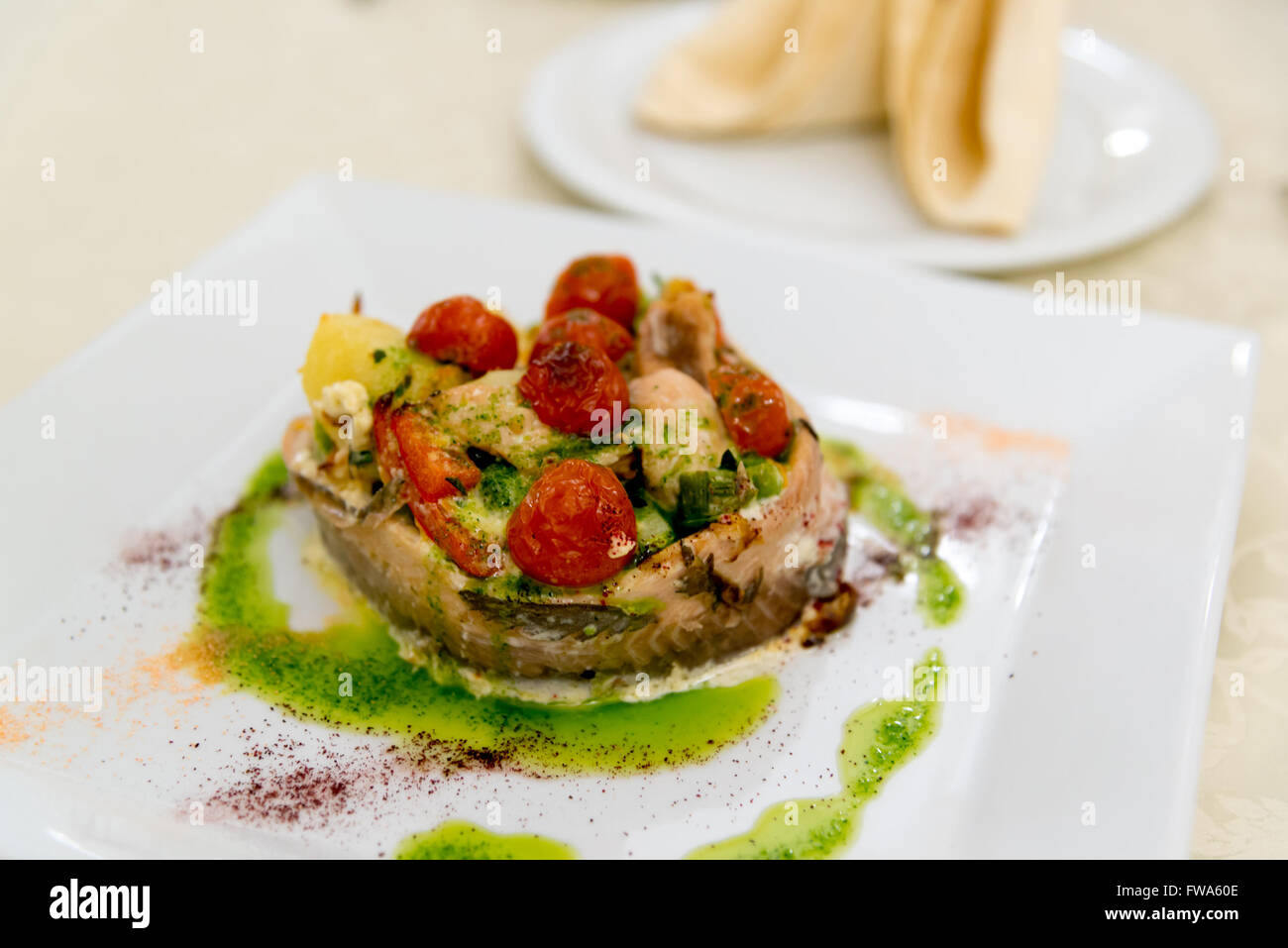 Fisch gebacken mit Kartoffeln und Tomaten Stockfoto