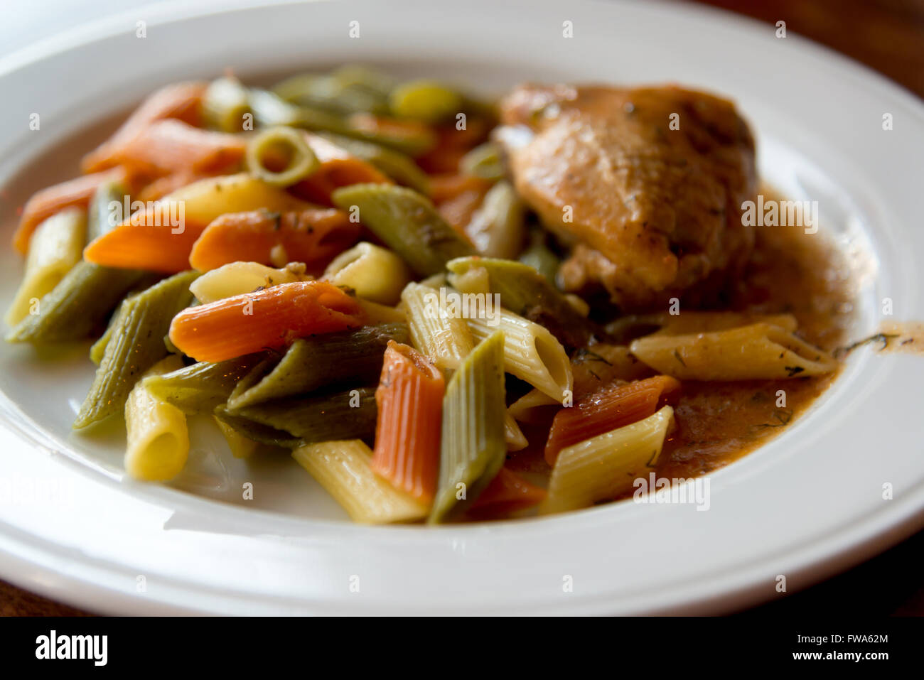 bunte Nudeln mit Huhn auf Teller Stockfoto