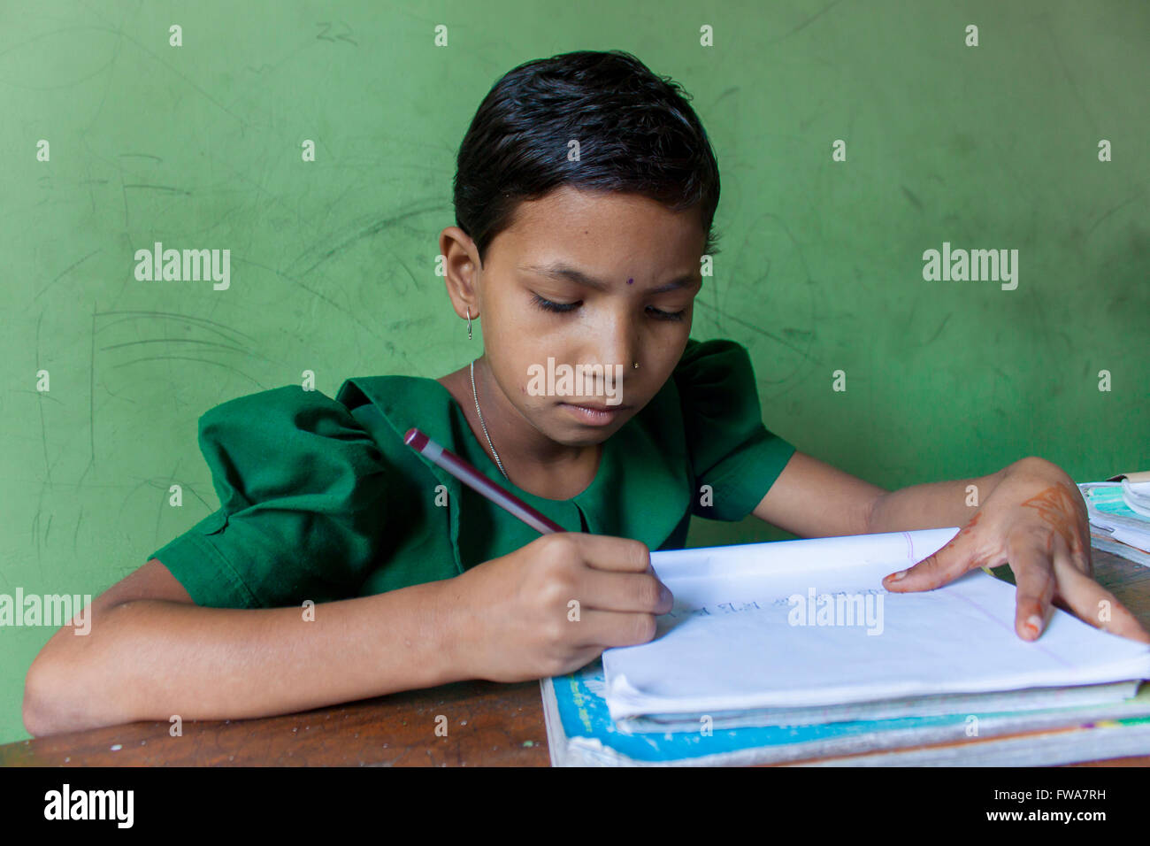 Ein kleines Mädchen schreiben Ngo ländlichen Grundschule Klassenzimmer unterstützt bei System Center, tangail, Dhaka © jahangir Alam onuchcha/alamy Stockfoto