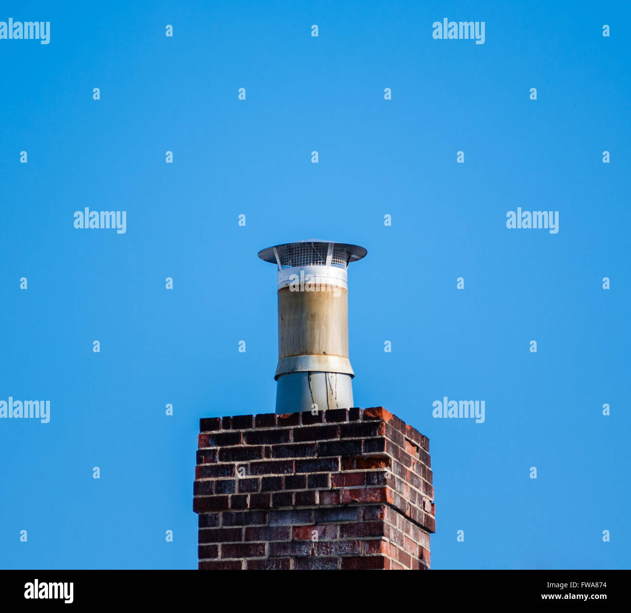 Nach oben von alten, dunklen gemauerten Schornstein mit Filter auf klaren blauen Himmel. Stockfoto