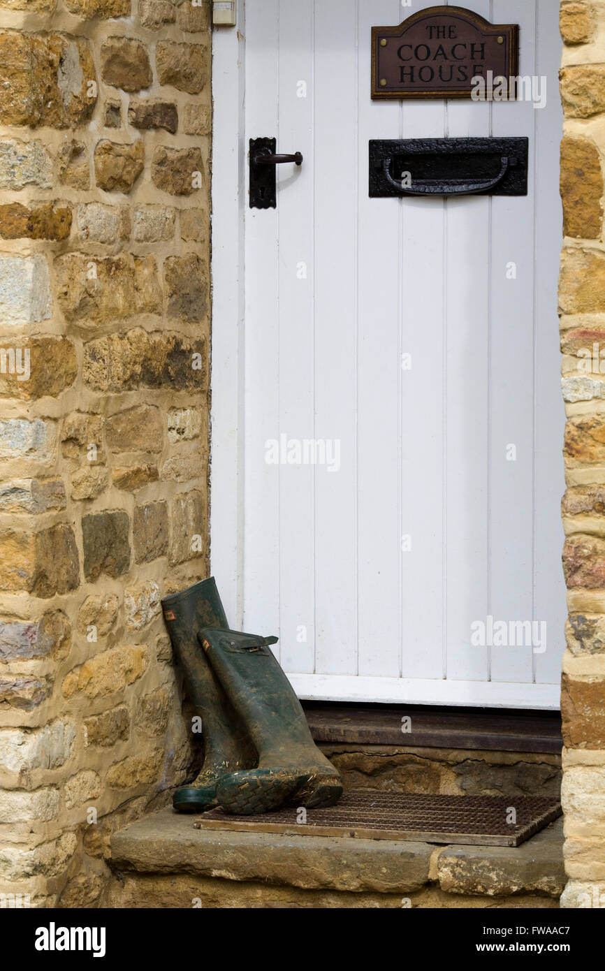 hölzerne Eingangstür mit Wellington boots in Tür in eine Landschaft Hütte Stockfoto