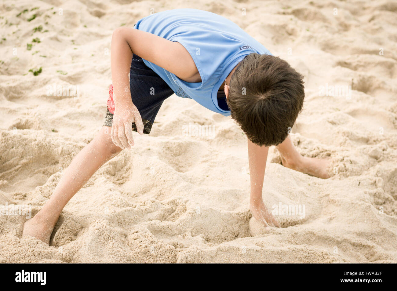 Kleinkind Jungen spielen mit Meeressand Strand an einem sonnigen Tag Stockfoto