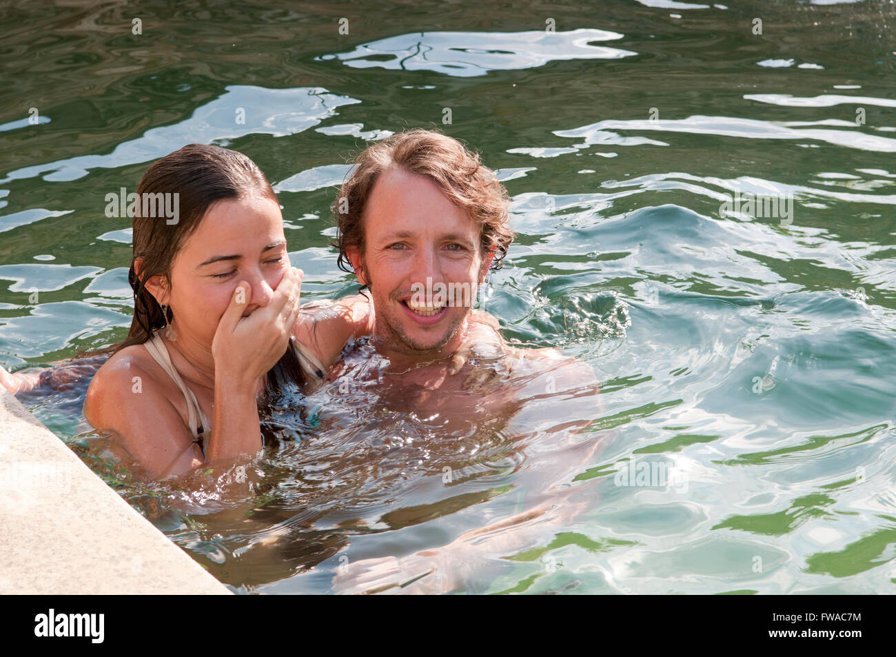 Junges Paar im Urlaub in einem Schwimmbad Herumspielen Stockfoto