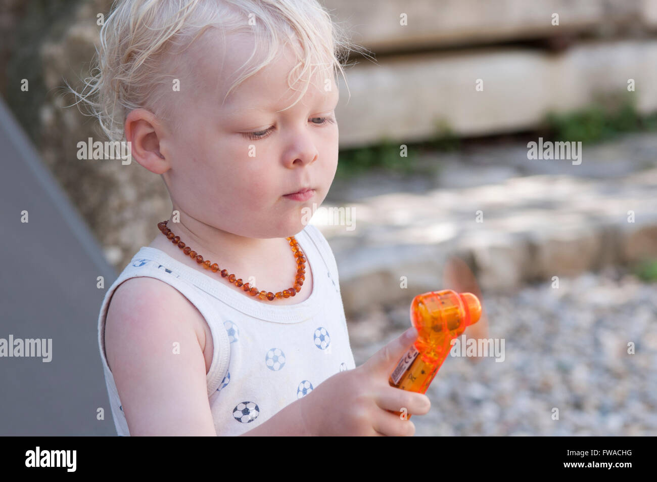 Kleinkind draußen im Garten, mit Batterie betrieben Fan sein, um kühl zu halten Stockfoto