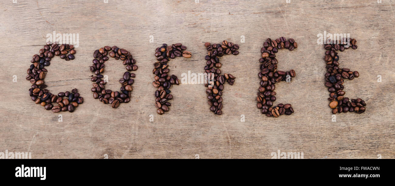 Inschrift Kaffee aus gerösteten Bohnen auf Holz Textur gelegt Stockfoto