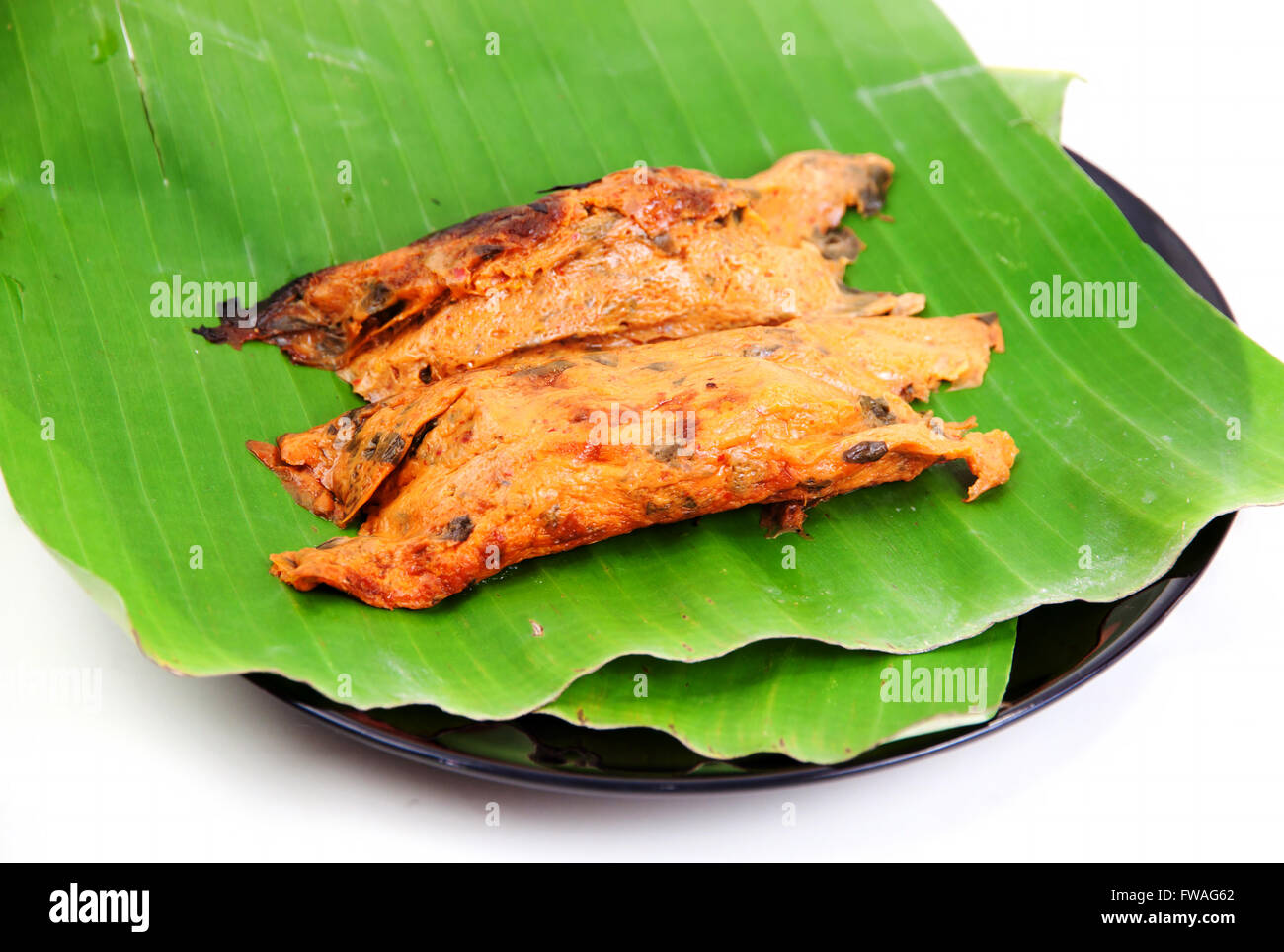 Fisch-Curry in Banane Blätter durch Hitze gegrillt auf weißem Hintergrund Stockfoto