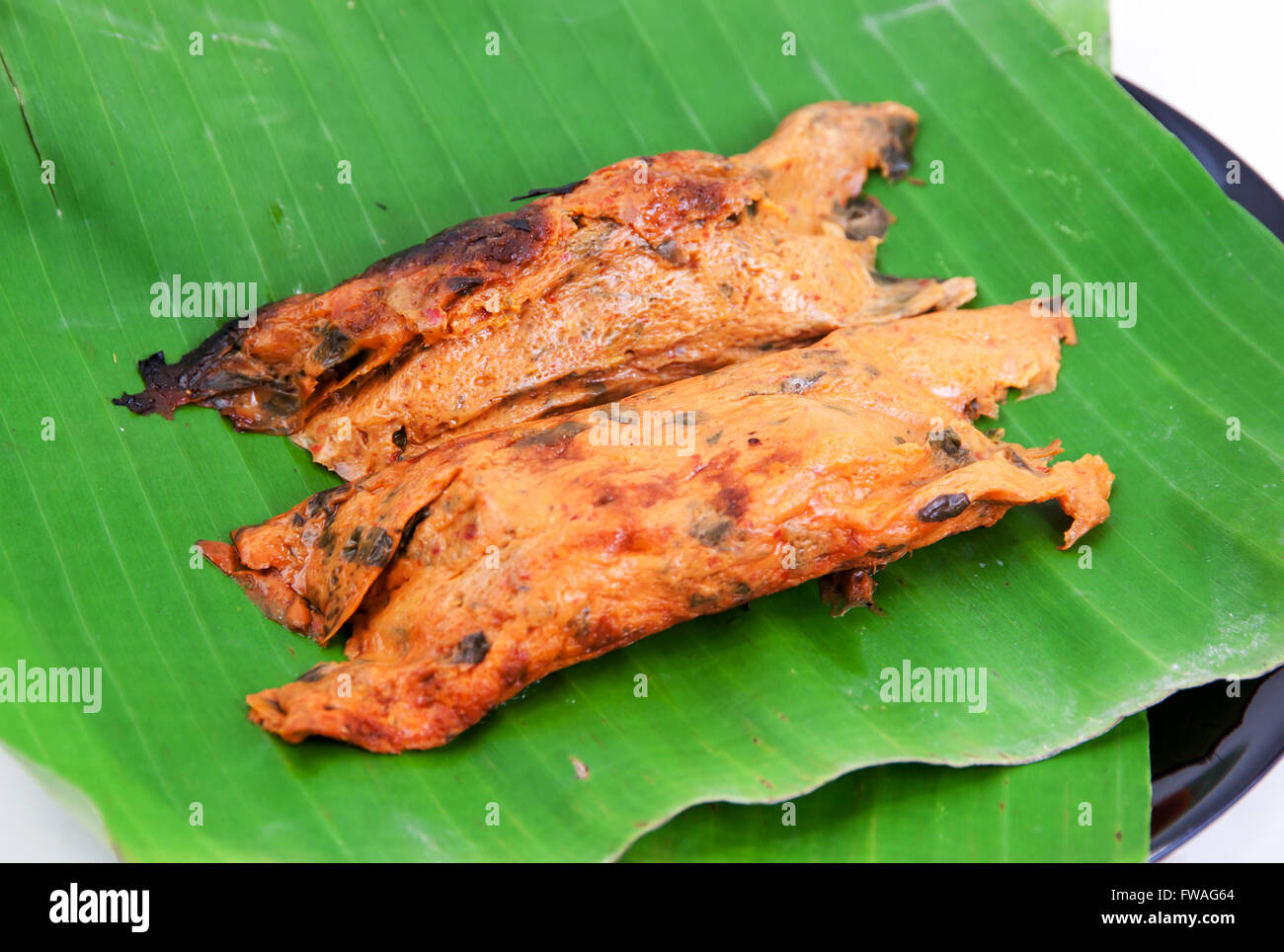 Fisch-Curry in Banane Blätter durch Hitze gegrillt auf weißem Hintergrund Stockfoto