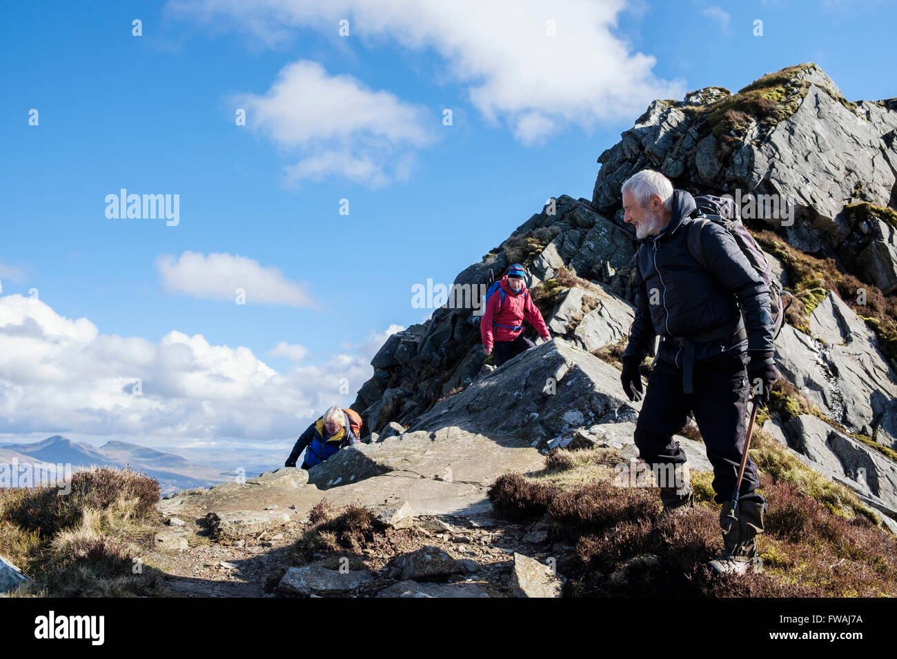 Wanderer, die Kriechen, Mynydd Drws-y-Coed Felsen auf Krippe Nantlle Ridge in den Bergen von Snowdonia National Park. Rhyd-Ddu, Gwynedd, Wales, Großbritannien, Großbritannien Stockfoto