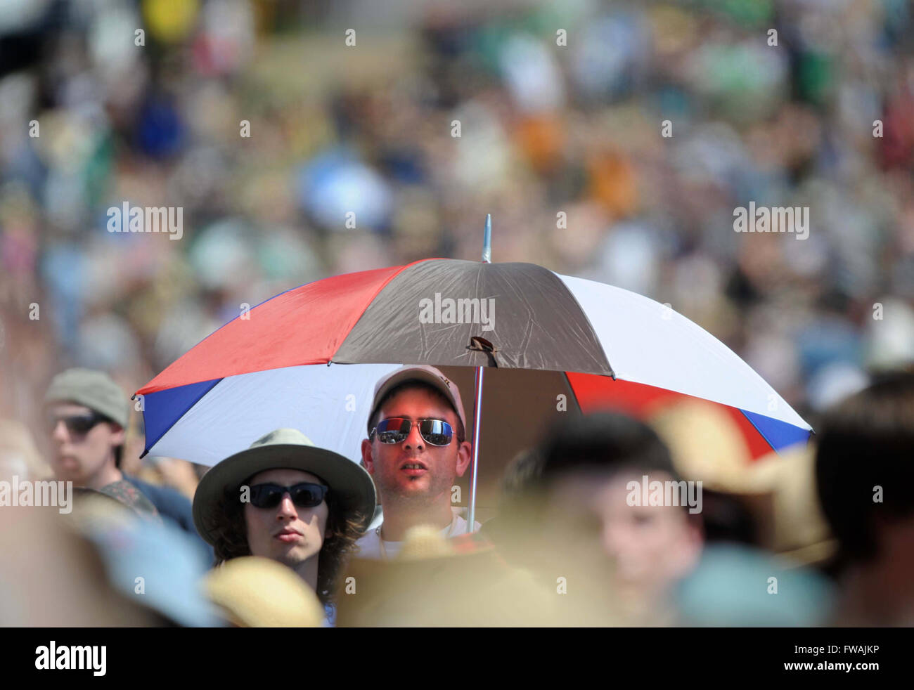 Ein Sonnenschirm spendet Schatten bei heißem Wetter im Jahr auf dem Glastonbury Festival 2010, Pilton Somerset UK Stockfoto