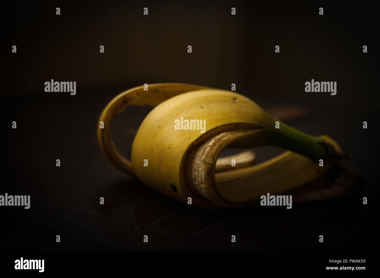 auf einem dunklen Hintergrund die Schale der Banane gegessen verdreht in form Stockfoto