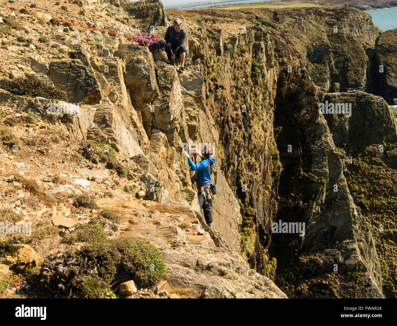 Junger Mann Klettern auf South Stack Klippen Isle of Anglesey Nord-Wales fast oben, beeindruckend und abenteuerlichen Klettererlebnis Stockfoto