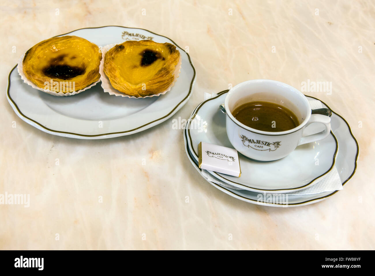 Tasse Kaffee und Pastel de Nata Gebäck serviert im Majestic Cafe, Porto, Portugal Stockfoto