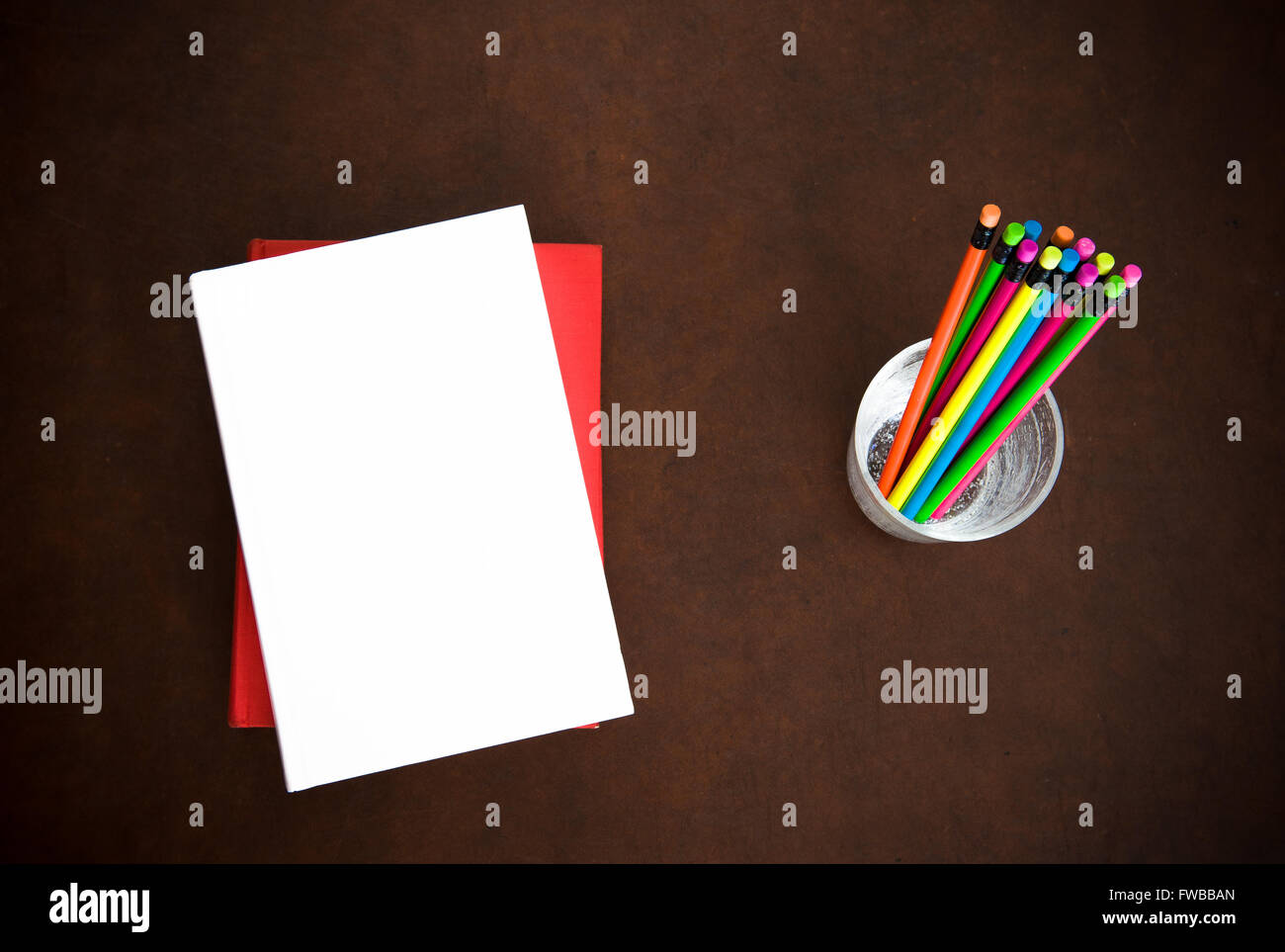 Schriftsteller-Desktopsymbol mit leeren Abdeckung Bücher und bunte Bleistifte auf Holz Stockfoto