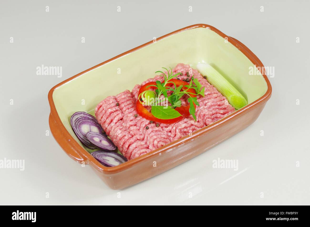 rohes Hackfleisch mit Zwiebeln und Rosmarin Stockfoto