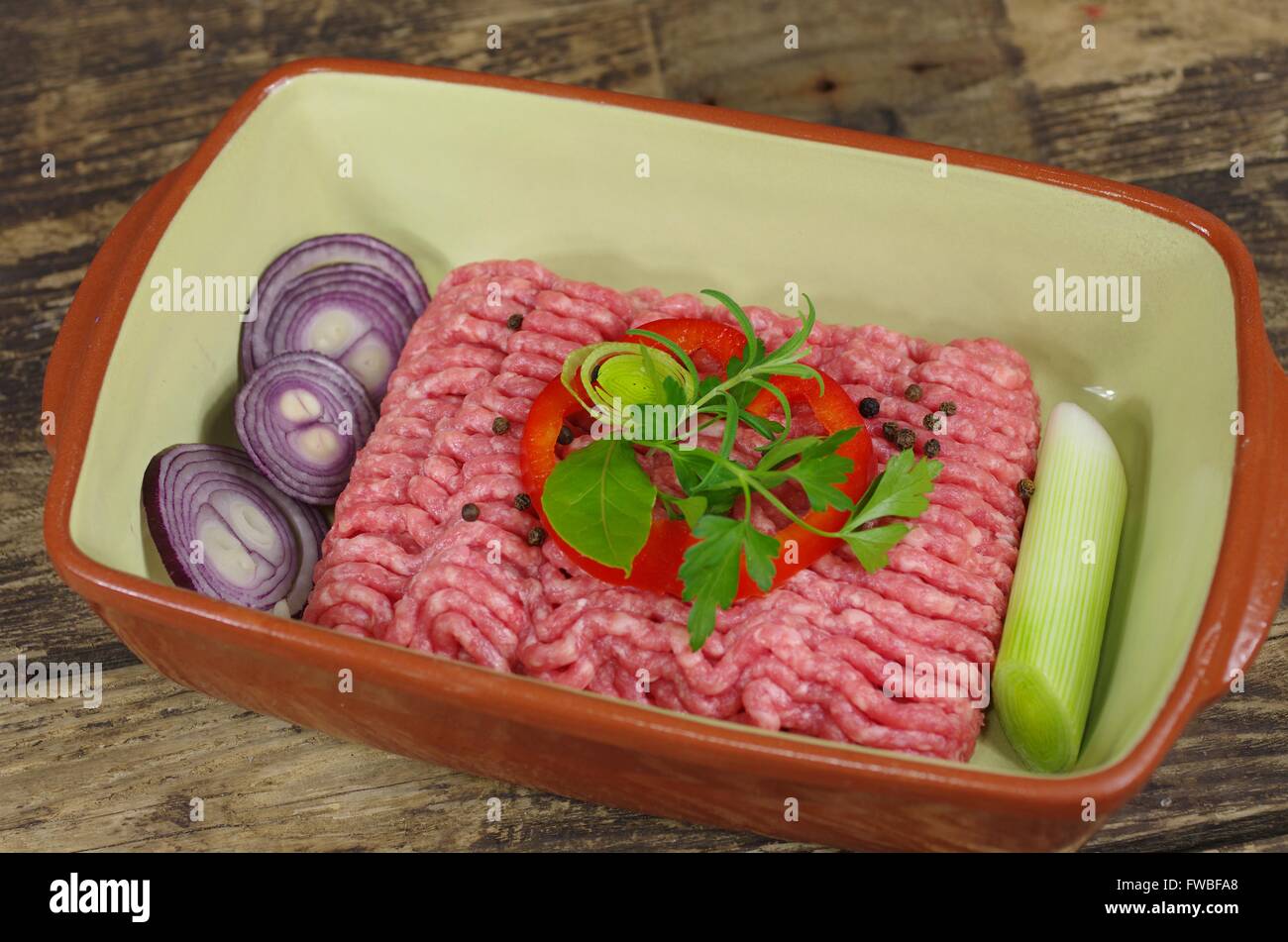 rohes Hackfleisch mit Zwiebeln und Rosmarin Stockfoto