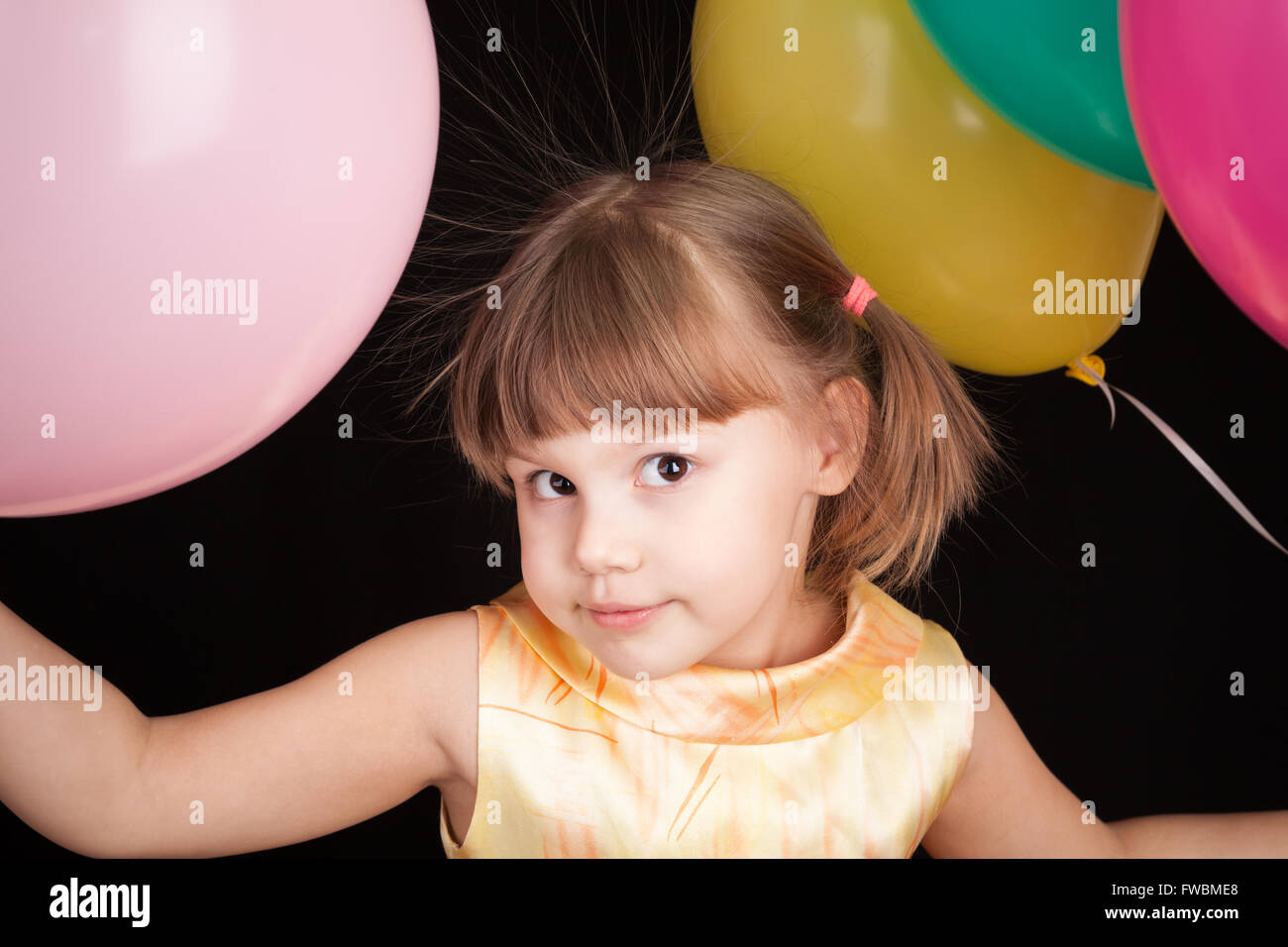 Studioportrait von lächelnden kleinen kaukasischen blondes Mädchen mit bunten Luftballons Stockfoto