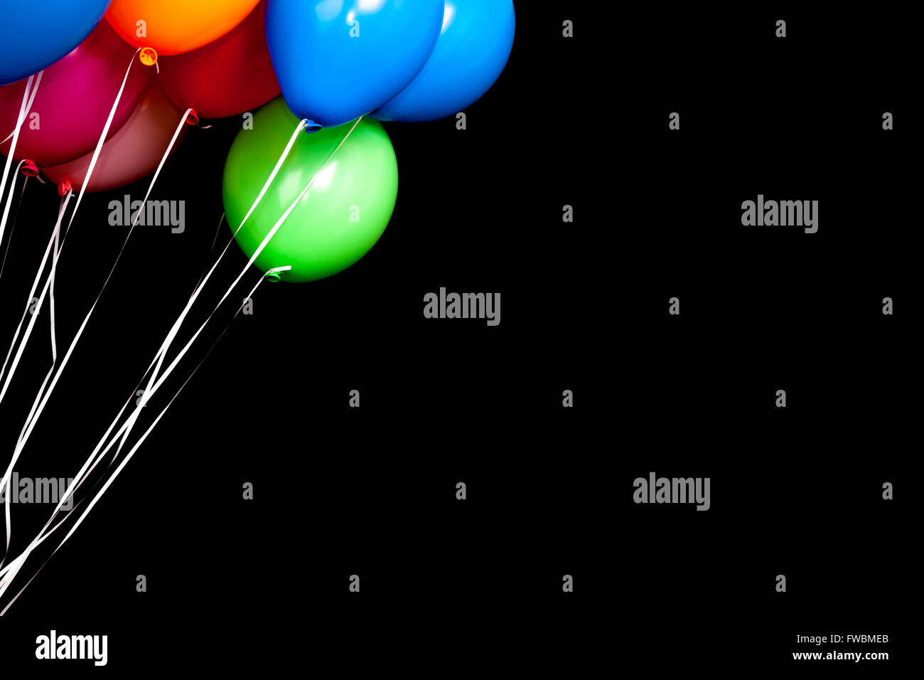 Bunte Luftballons auf Bändern auf schwarzem Hintergrund Stockfoto Bunte Luftballons auf Bändern auf schwarzem Hintergrund Stockfoto