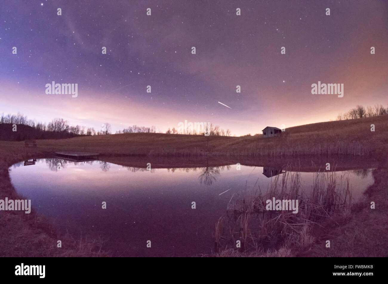 Die internationale Raumstation ISS-Streifen über den Nachthimmel kurz nach der Dämmerung von einem Teich reflektiert. Stockfoto