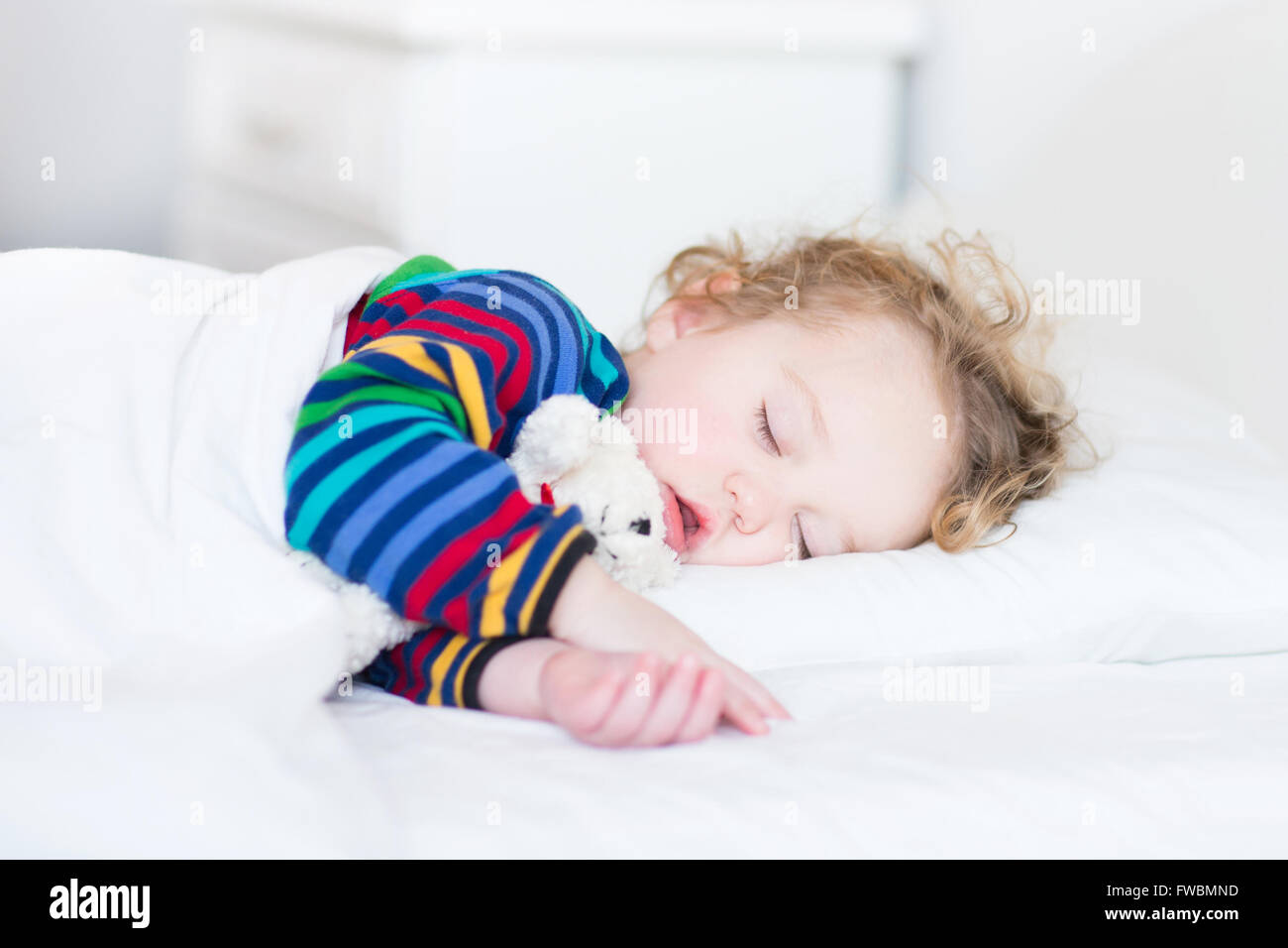 Niedliche schlafendes Kleinkind Mädchen in einem weißen Bett Stockfoto