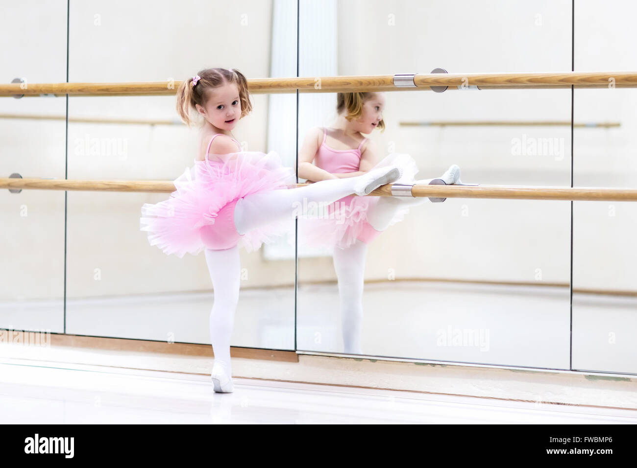 Ballerina-Mädchen in einem rosa Tutu. Entzückenden Kind Tanzen Ballett in einem weißen Studio. Kinder tanzen. Stockfoto