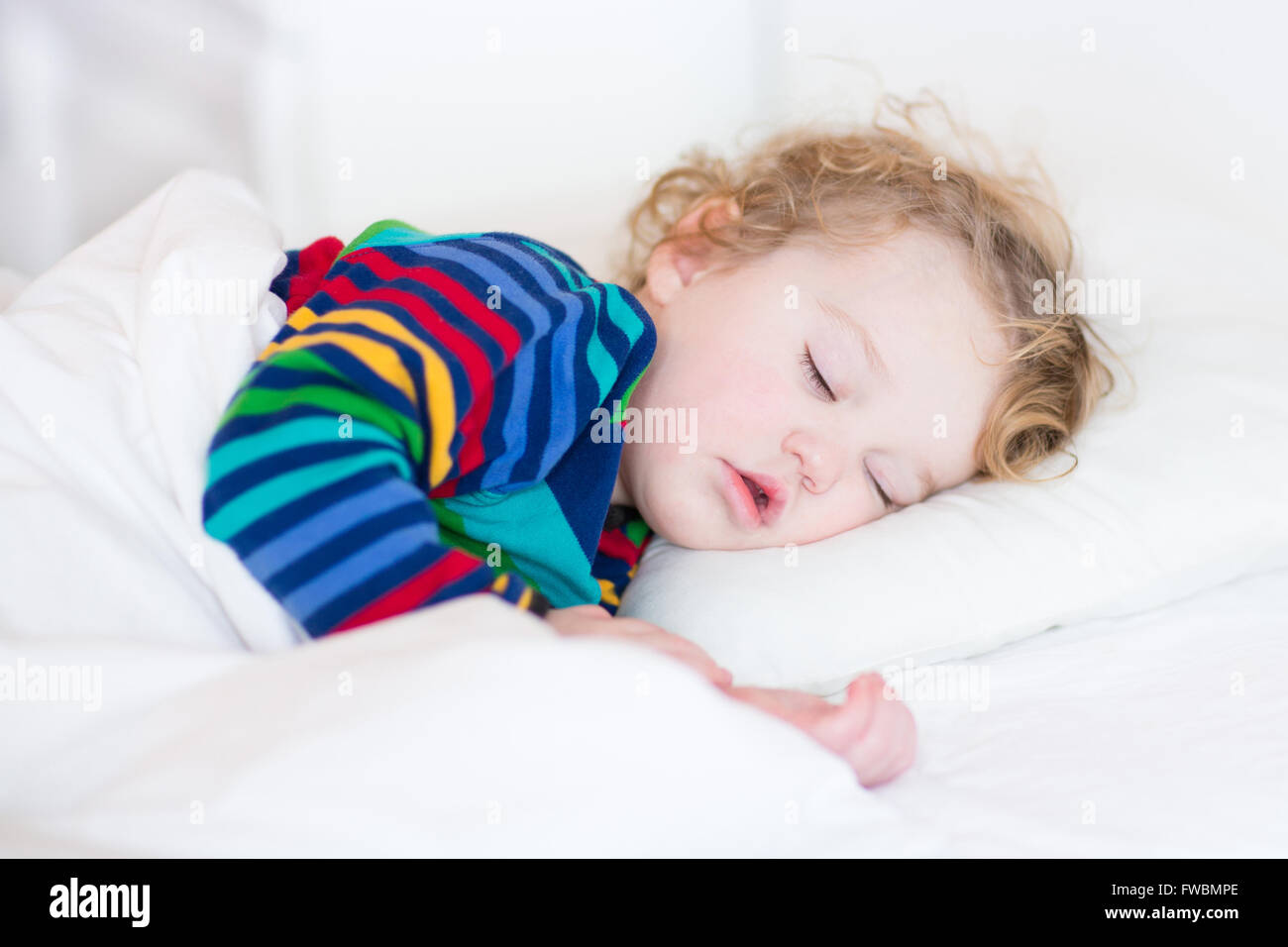 Niedliche schlafendes Kleinkind Mädchen in einem weißen Bett Stockfoto