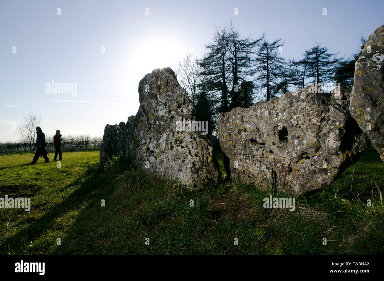 Wanderer eine Tour rund um den Steinkreis und Einzelsteine bekannt als die "Rollright Stones", ein Steinkreis der Jungsteinzeit auf einem Hügel in Oxfordshire, UK. Der Steinkreis wird berichtet, dass von Menschen rund um 12:00 vorgenommen wurden. Stockfoto