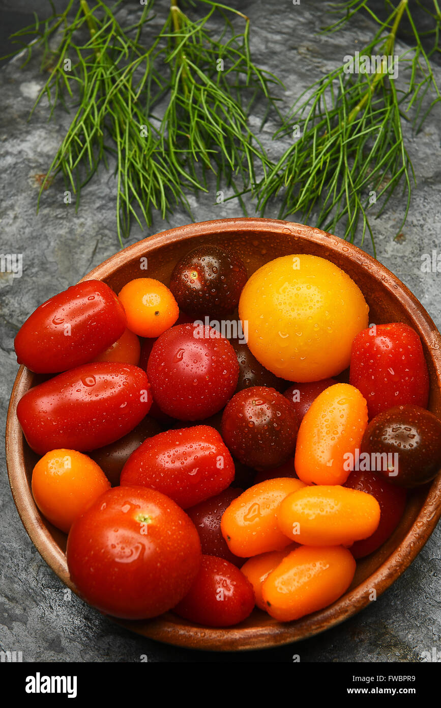 Draufsicht auf eine Schale mit frischen Medley Tomaten auf einem Schieferoberfläche abgeholt. Hochformat. Stockfoto