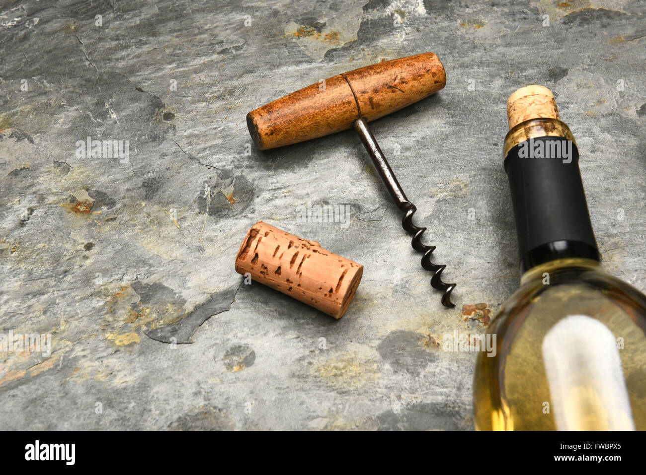 Draufsicht einer Wein Flasche und Korken Schraube auf einem Schieferoberfläche. Stockfoto