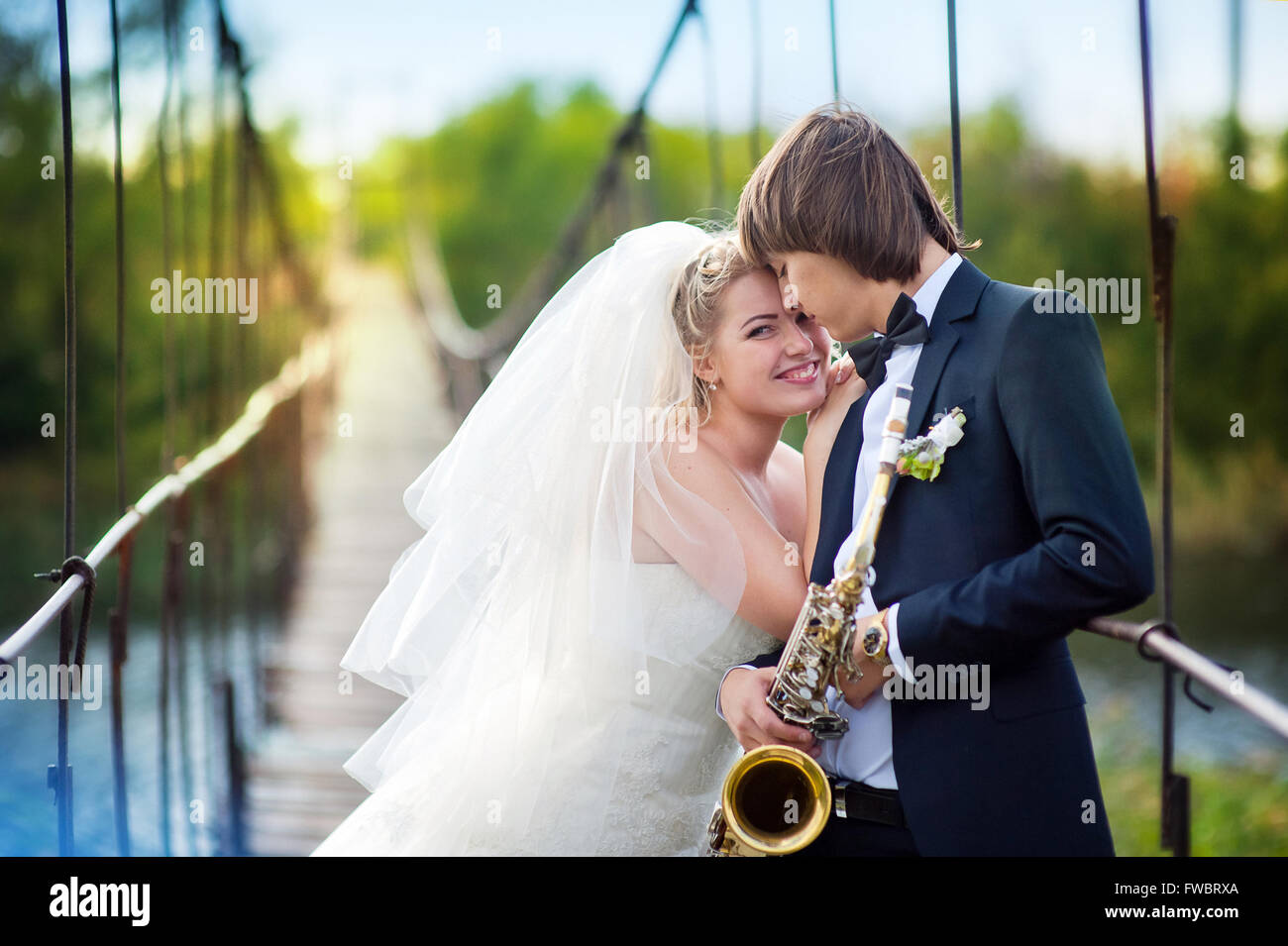 Braut und Bräutigam mit Sax stehen auf Brücke Stockfoto