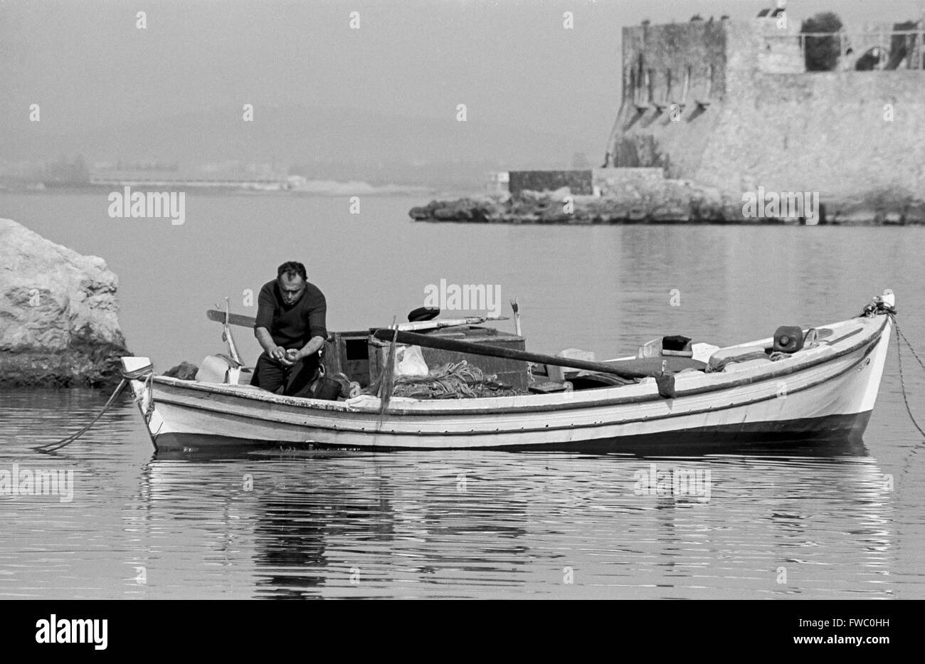Ein Fischer im Hafen von Nafplio, in Peloponnisos, Griechenland. Stockfoto