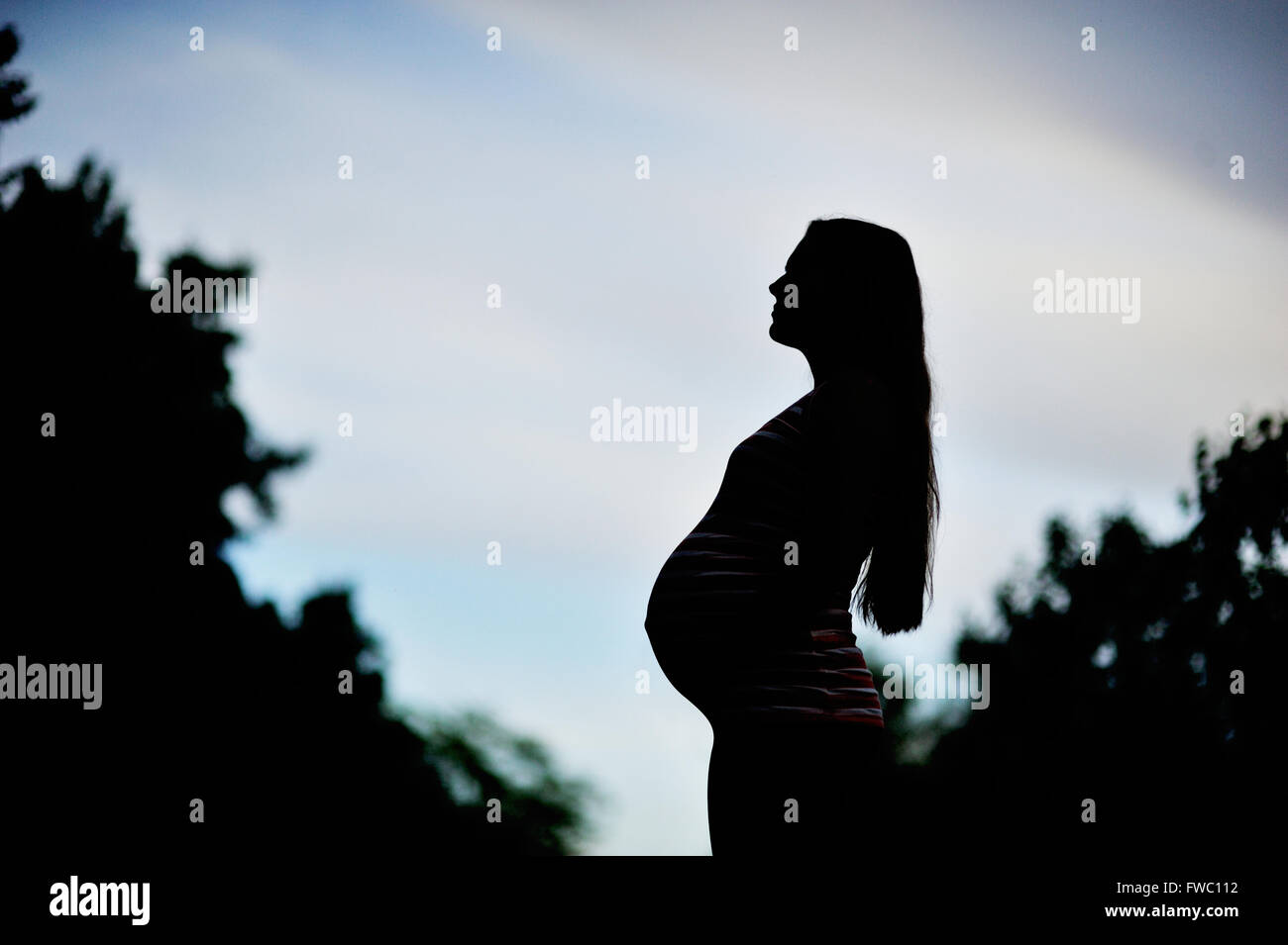 Schöne schwangere Frau entspannende außerhalb Stockfoto