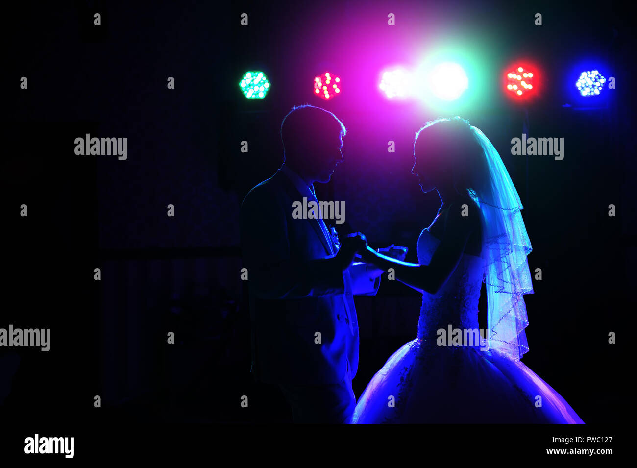 Küssen Sie und tanzen Sie Braut und Bräutigam in dunklen Festsaal Stockfoto