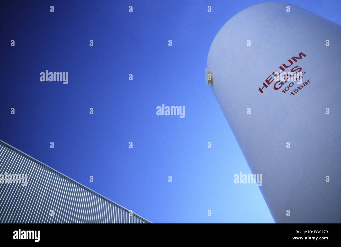 Heliumgastanks an einem Industriestandort vor tiefblauem Himmel. Stockfoto