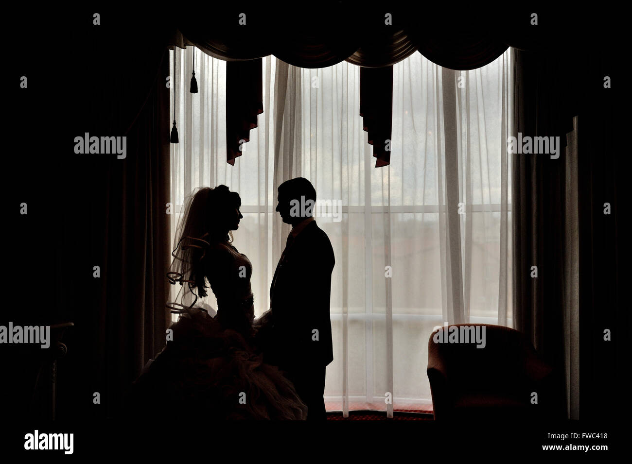 Silhouette der Braut und Bräutigam auf dem Hintergrund eines Fensters Stockfoto