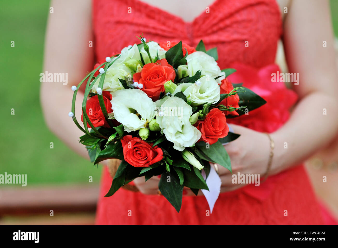Braut im roten Kleid hält Hochzeit bouquet Stockfoto