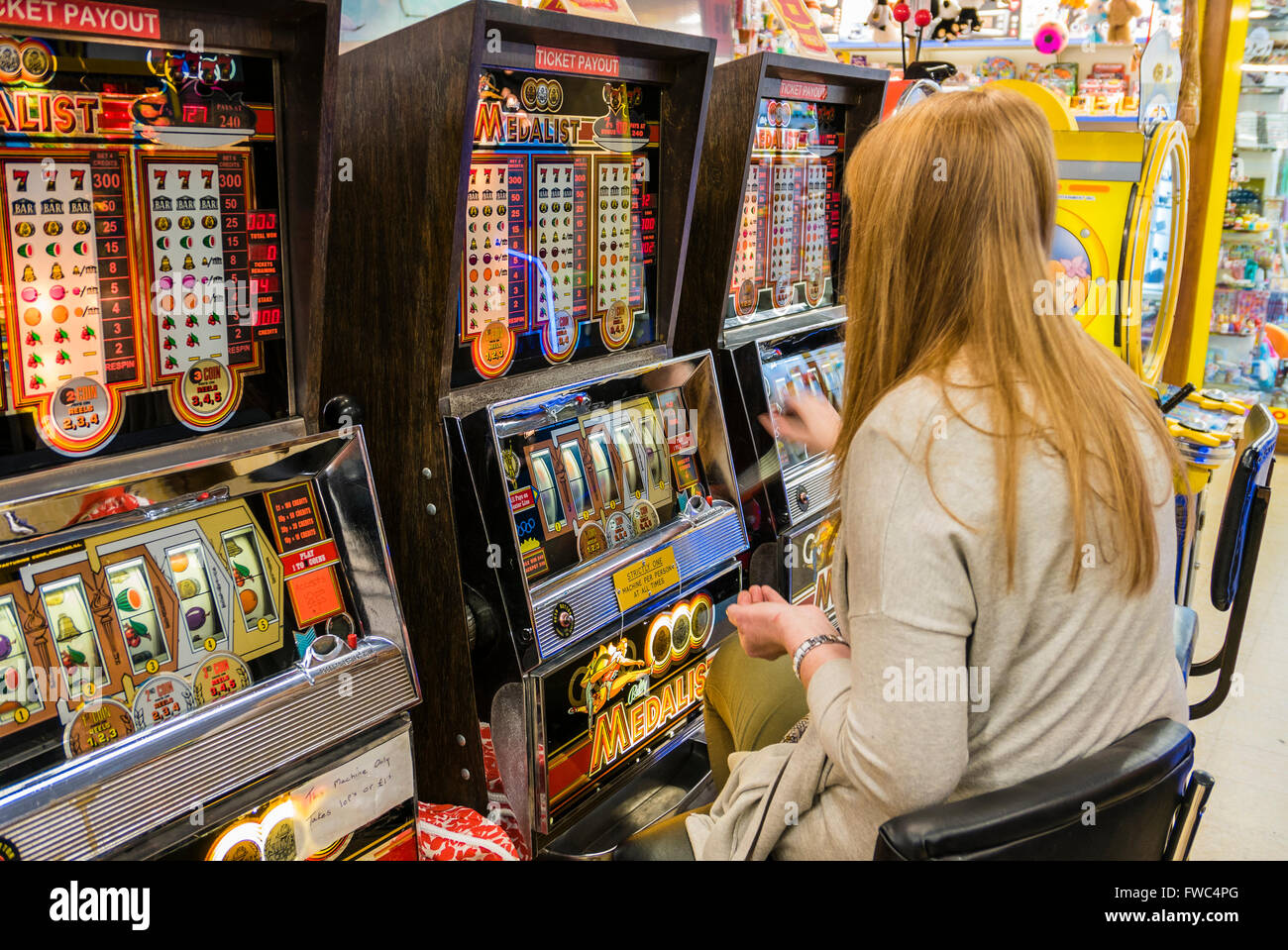 Eine 2P Spielautomat spielt eine Frau in einer Kirmes in einem britischen Badeort. Stockfoto