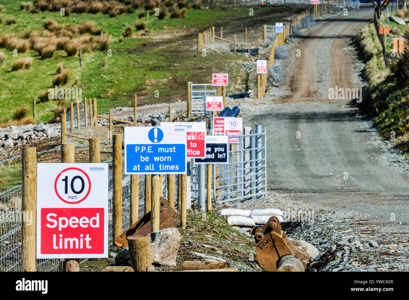 Zeichen auf dem Weg einer Baustelle einschließlich Geschwindigkeitsbegrenzung, PSA werden etc. getragen. Stockfoto