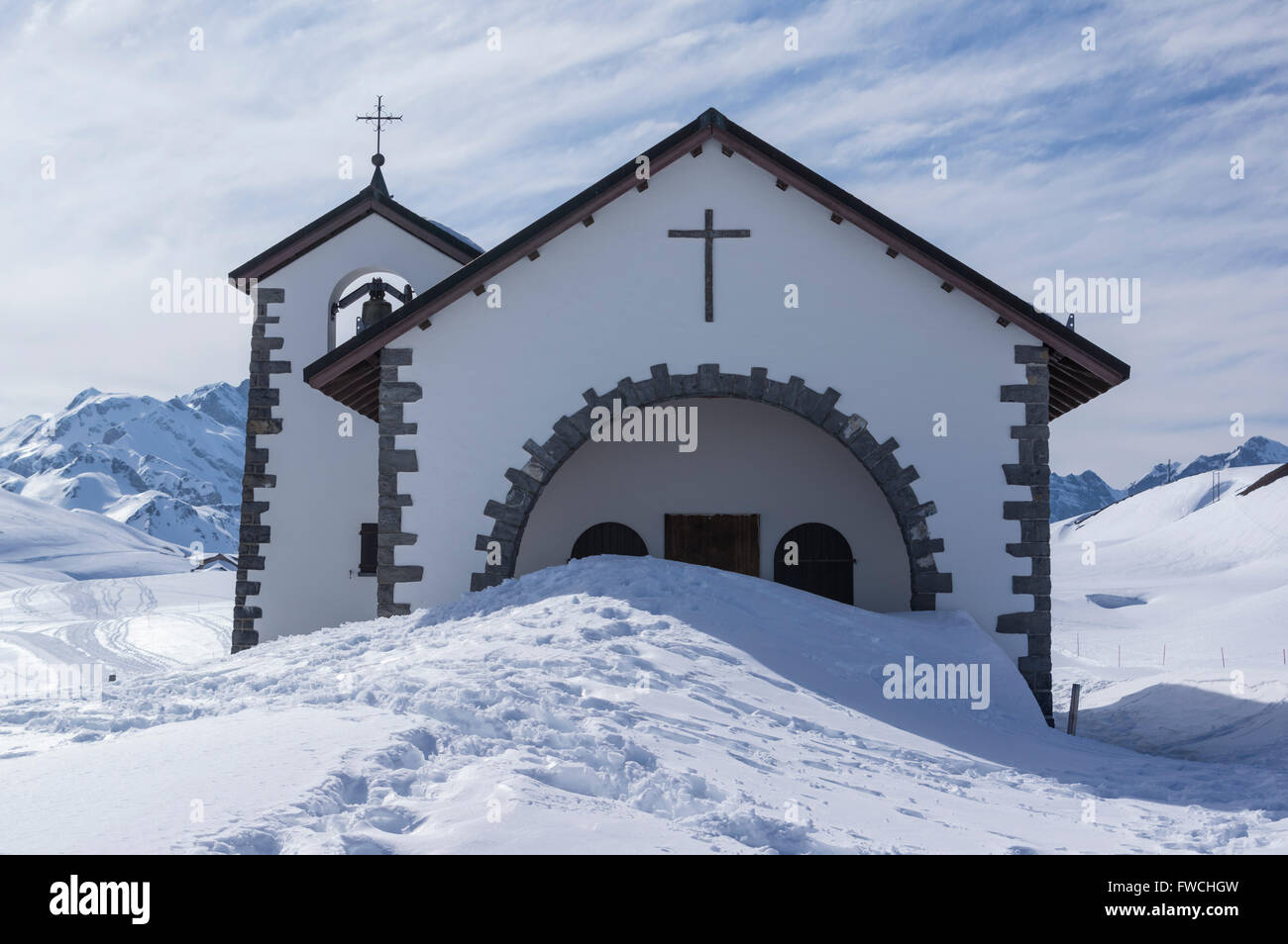 Eingang der Kapelle in den Schweizer Alpen durch Schnee blockiert. Tannalp, Melchsee-Frutt, Schweiz. Berge im Hintergrund. Stockfoto