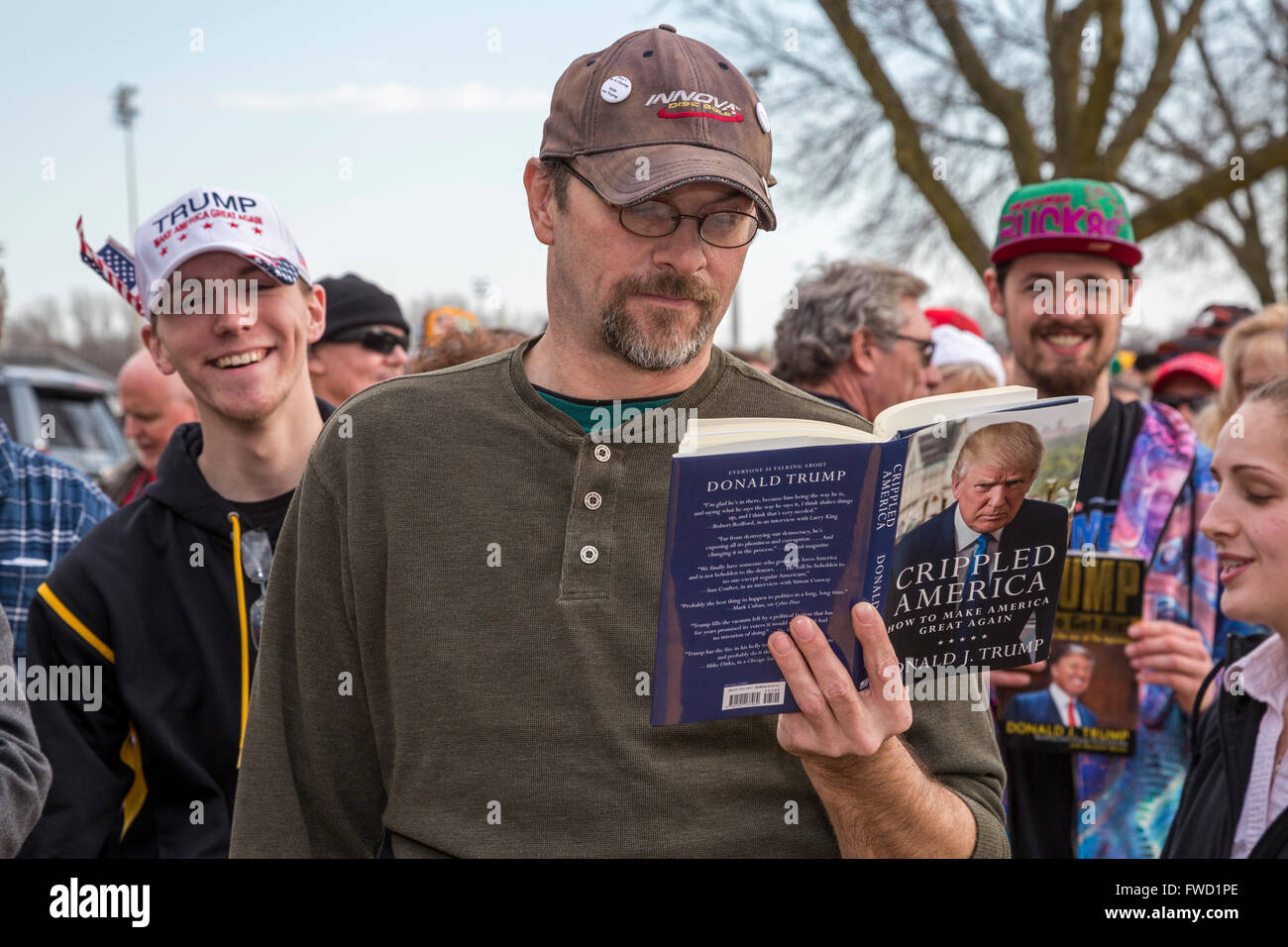West Allis, Wisconsin USA - 3. April 2016 - ein Mann liest ein Donald Trump Buch während der Wartezeit in einer langen Schlange für die Zulassung zu einer Trumpf-Kampagne-Rallye. Bildnachweis: Jim West/Alamy Live-Nachrichten Stockfoto