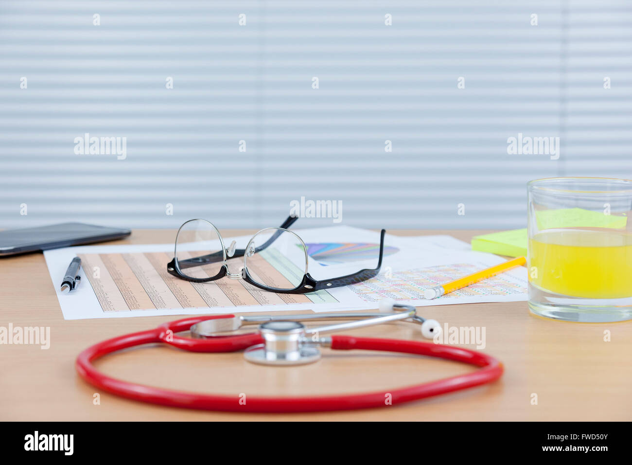 Verlegung auf einem Ärzte-Schreibtisch mit einem Stethoskop und Handy-Brille Stockfoto