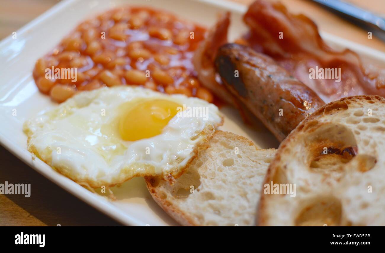 Warmes Frühstück mit Toast, Speck, Spiegelei, Würstchen und Bohnen Stockfoto