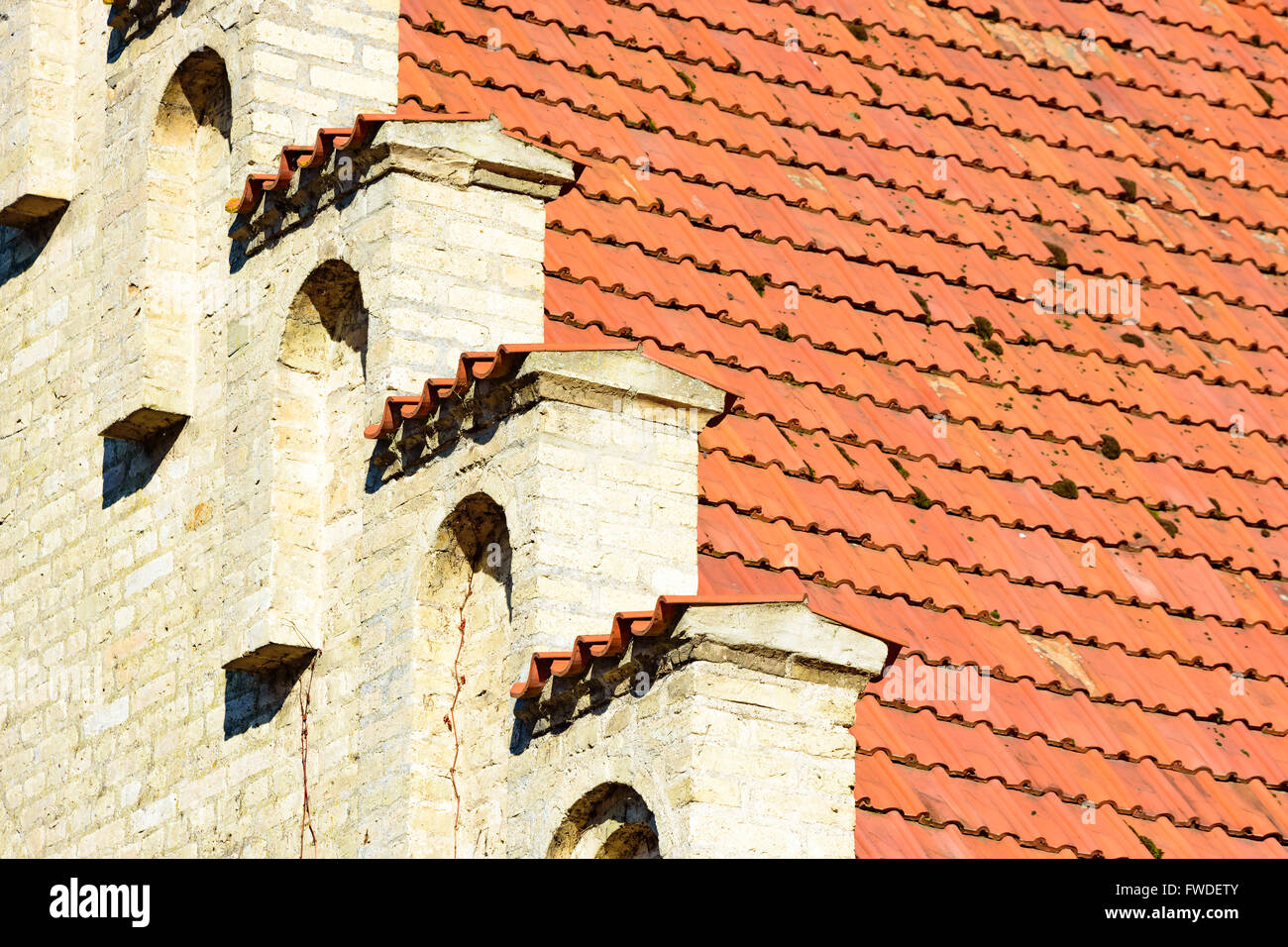 Schöne architektonische Details eines alten gemauerten Hauses die gelbe Fassade das rote Ziegeldach trifft. Stockfoto