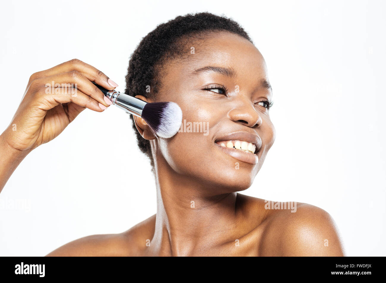 Lächelnde Afro Amerikanerin Schminken mit Pinsel isoliert auf weißem Hintergrund Stockfoto