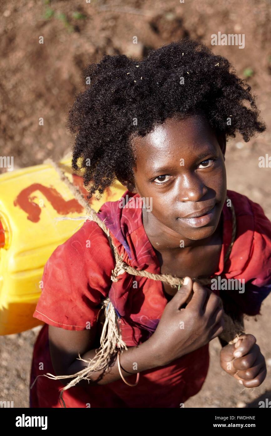 Ein junge äthiopische Mädchen sammelt und transportiert Wasser. Stockfoto