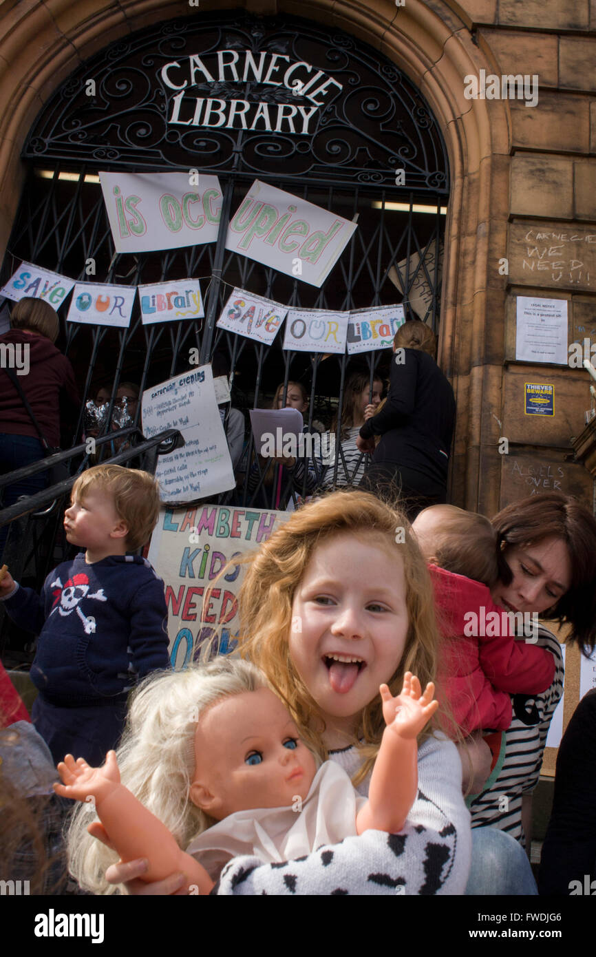 Kinder und Aktivisten protestieren die Schließung von Lambeth Rat der Carnegie-Bibliothek am 3. Tag der Besetzung in Herne Hill, South London am 3. April 2016. Die böse Gemeinde im Stadtteil South London haben ihre wichtige Ressource für Lern- und gesellschaftlicher Mittelpunkt für das Wochenende besetzt. Nach einer langen Kampagne von einheimischen Lambeth voraus gegangen und die Bibliothek Türen zum letzten Mal geschlossen, da sie sagen, schneidet, um ihren Haushalt bedeuten, dass Millionen gerettet werden müssen. Ein Fitness-Studio wird die Bibliothek ersetzen und keine Bibliothekare werden anwesend sein, während einige der 20.000 Bücher in den Regalen bleiben, Stockfoto