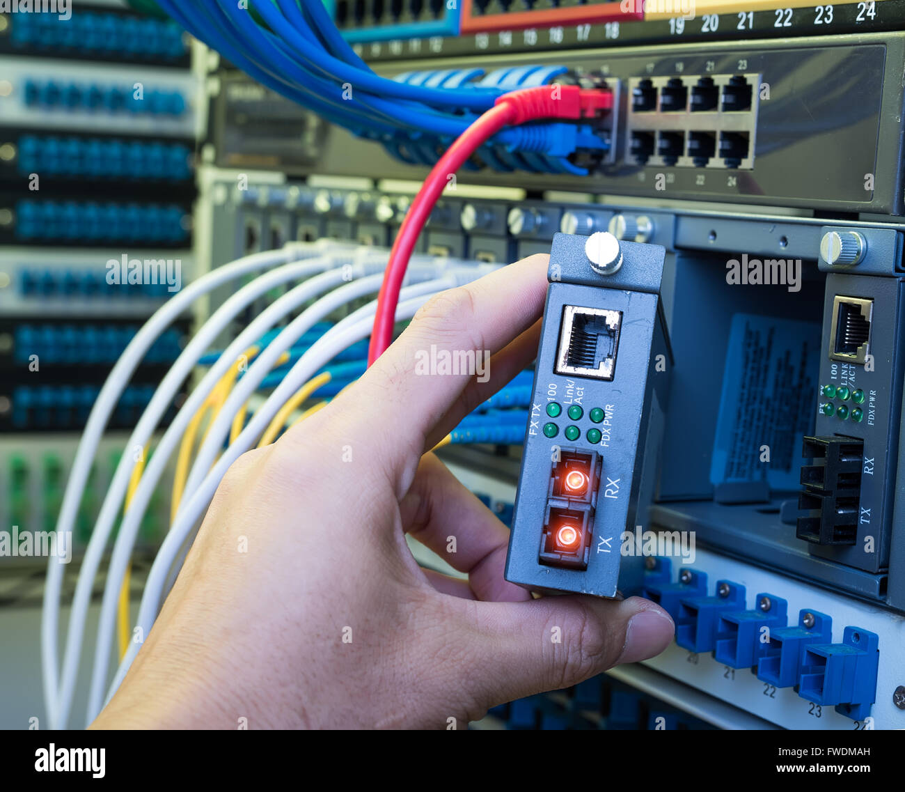 Mann bei der Arbeit im Netzwerk Server Zimmer mit LWL-Hub für die digitale Kommunikation und Internet Stockfoto