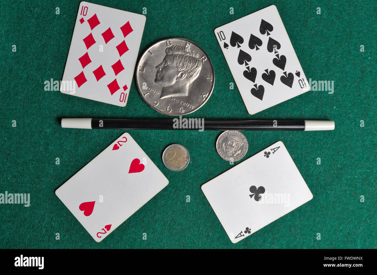 Zauberstab mit europäischen und amerikanischen Münzen auf einer grünen Casino-Matte Stockfoto
