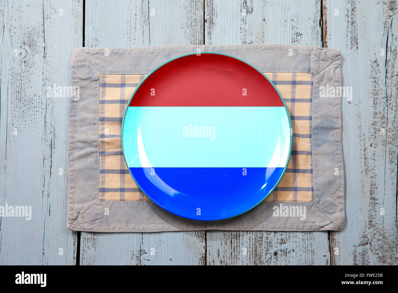 Leeren Teller mit niederländischer Flagge auf hellblauem Hintergrund aus Holz Stockfoto
