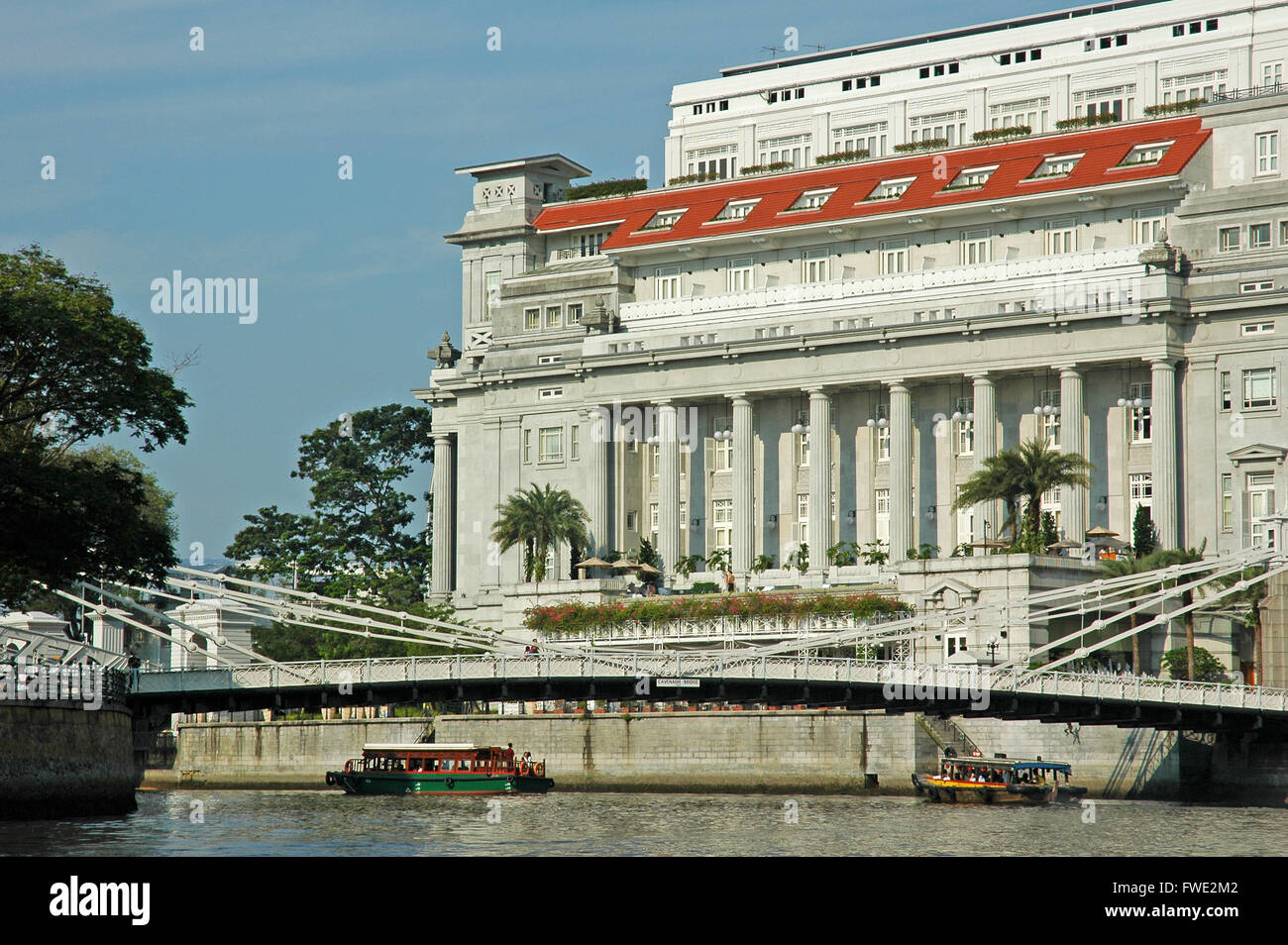 Fullerton Hotel und Cavenagh Brücke, von der Singapore River. Stockfoto