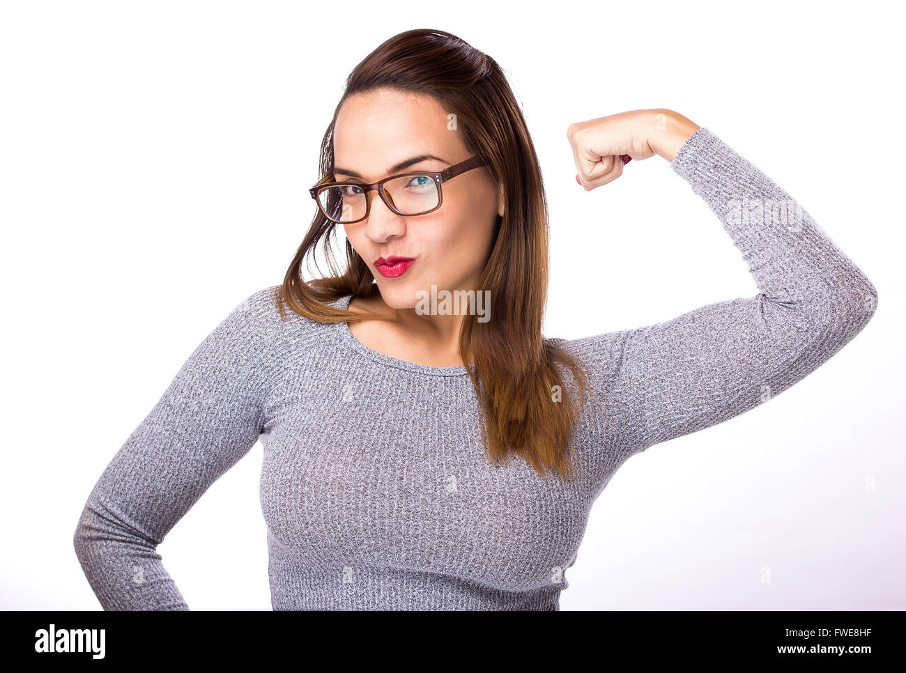 gewinnende Frau glücklich feiern Erfolg. Sie trägt Brille und grauen Pullover auf weißem Hintergrund Stockfoto